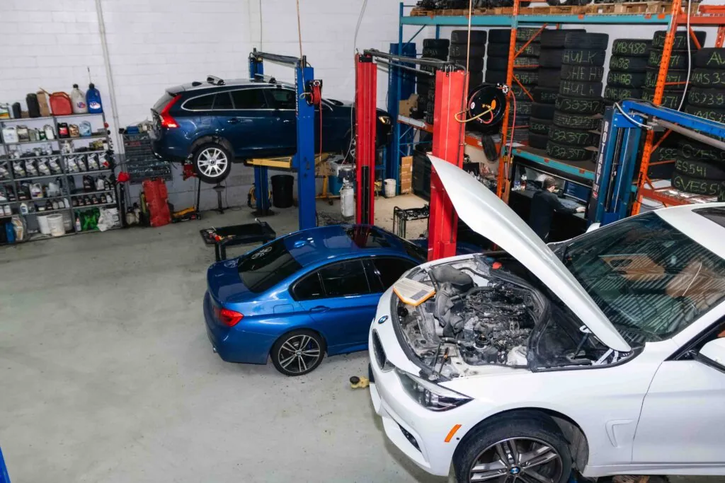 European cars in the service bays, one BMW with the hood up